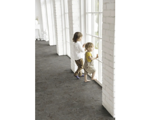 Deti stoja pri okne vo svetlej miestnosti s tmavou podlahovou krytinou