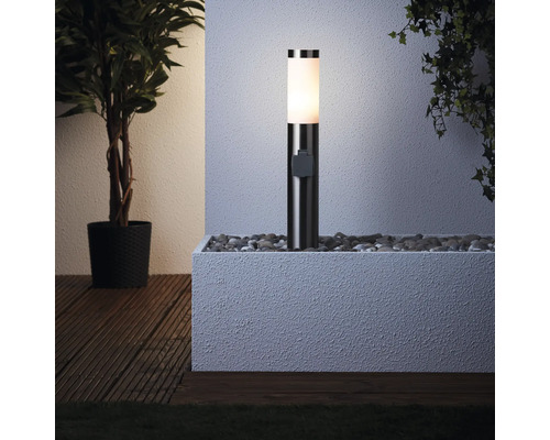 Osvetlené pätkové svietidlo v kvetináči plnom kameňov vedľa rastliny