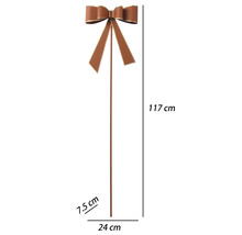 Hnedý kovový záhradný zápich s mašľou, výška 117 centimetrov, šírka 24 centimetrov, hĺbka 7,5 centimetra.