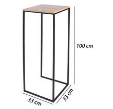 Vysoký stojan na kvety s čiernym kovovým rámom a svetlou doskou v dekore dreva, rozmery 100 centimetrov výška a 33 na 33 centimetrov šírka.